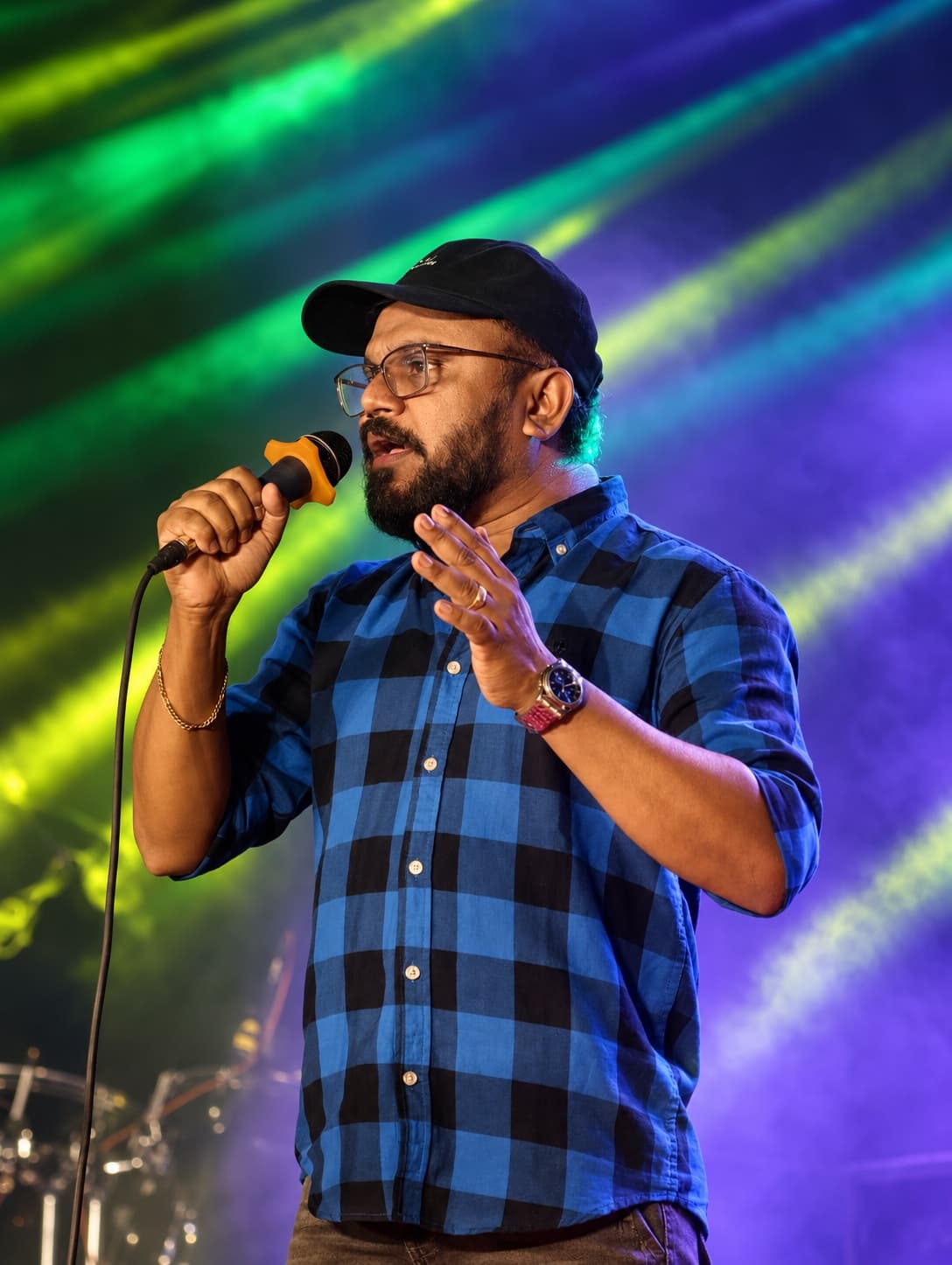 Originals Orchestra vocalist performing under colourful stage lights