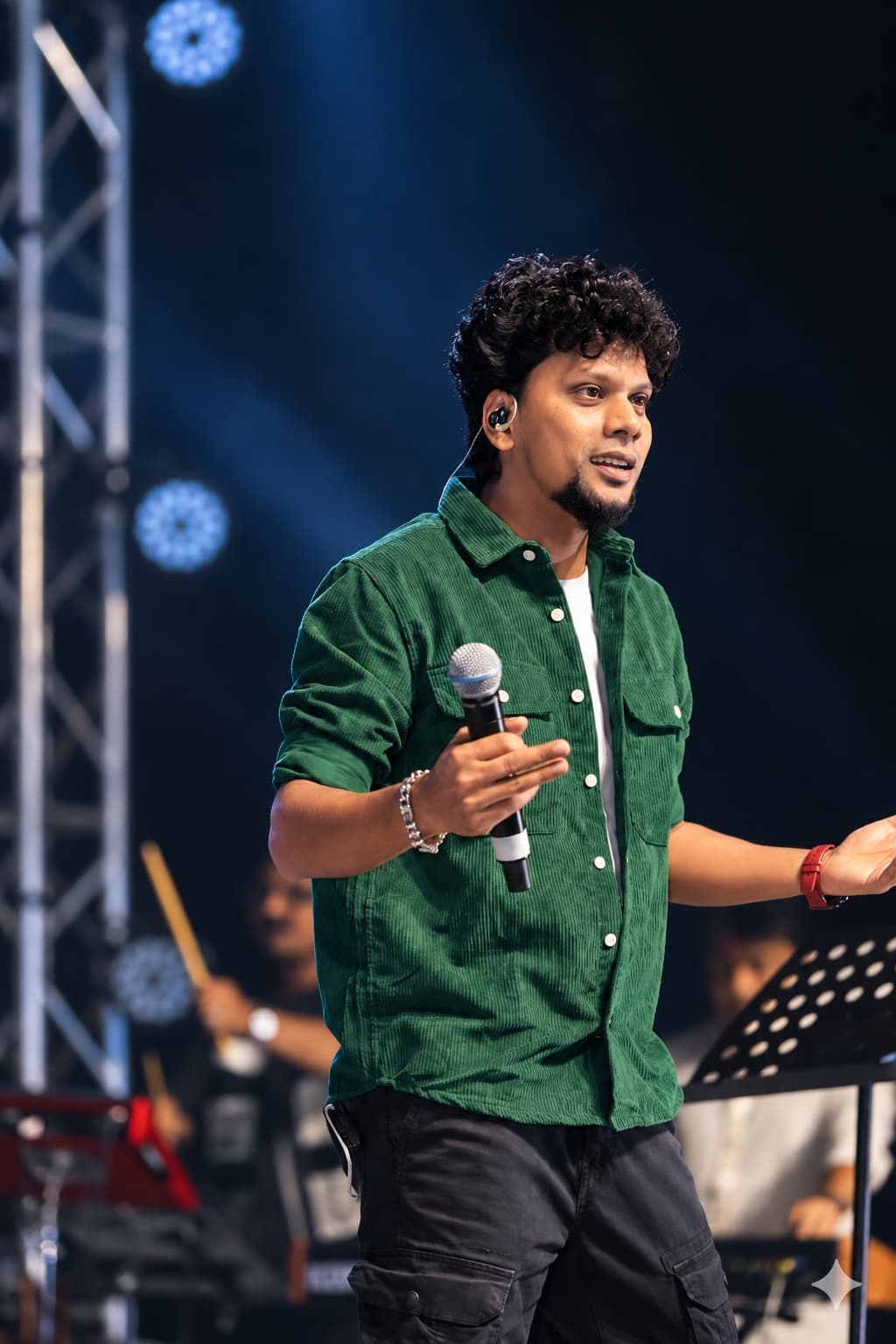 Originals Orchestra singer in a green shirt performing with a microphone